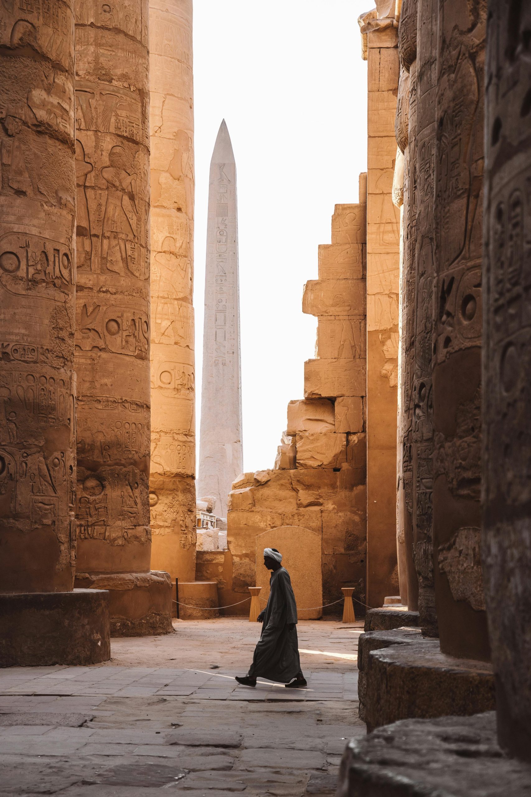 A serene view of the Karnak Temple's ancient columns and obelisk with a person walking through.Photographer taking a picture of the Pyramid of Giza under the bright Egyptian sun.Hani- travel - резервирайте lux- аранжмани Hugrada Egipet, all inclusive , пирамидиHani- travel - резервирайте lux- аранжмани Hugrada Egipet, all inclusive , пирамиди