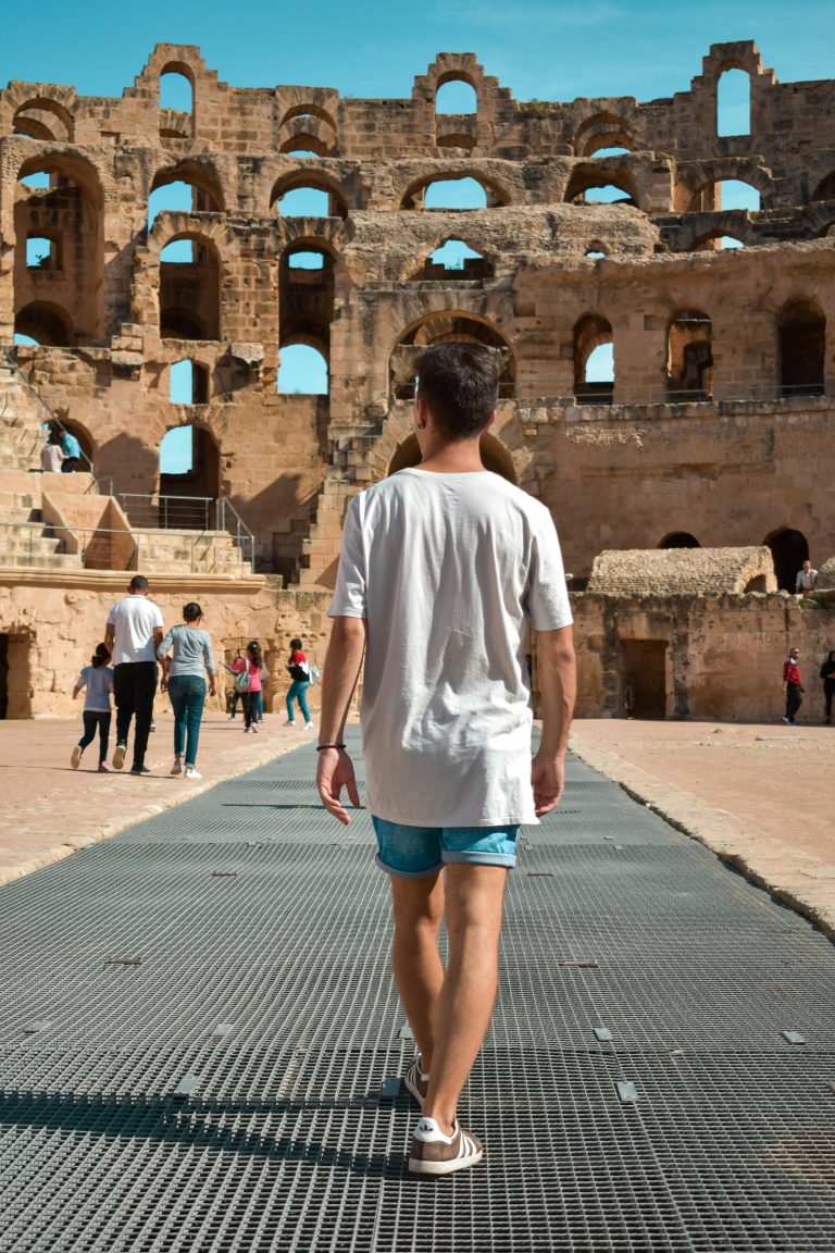 Man walking through the historic El Jem amphitheatre in Tunisia, a popular tourist attraction.hani travel тунис летни одмори